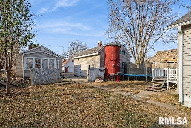 exterior space with a trampoline, a shed, and a deck