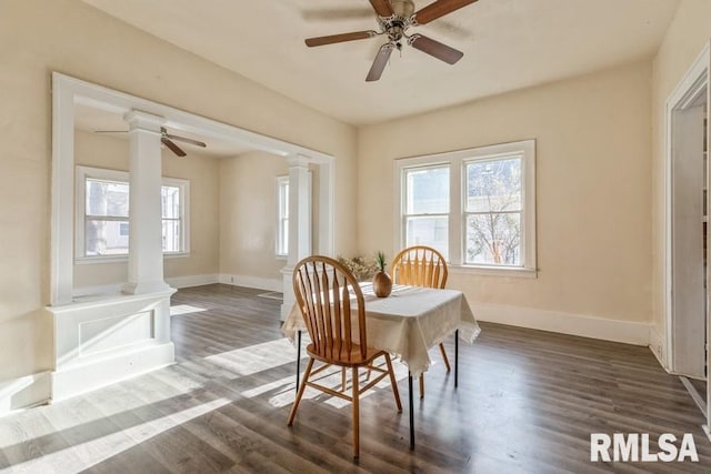 dining space with dark hardwood / wood-style floors, ceiling fan, and decorative columns