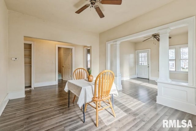 dining area featuring dark hardwood / wood-style flooring, decorative columns, and ceiling fan