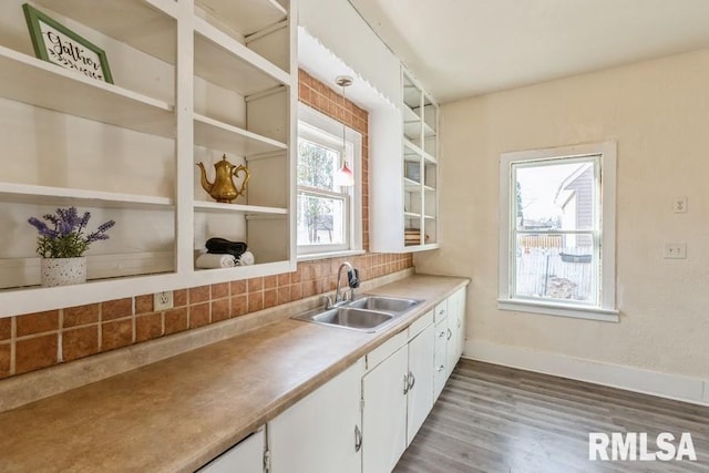 kitchen featuring decorative backsplash, white cabinetry, sink, and light hardwood / wood-style floors