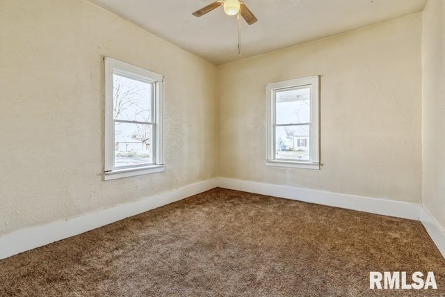 carpeted empty room with ceiling fan and a healthy amount of sunlight