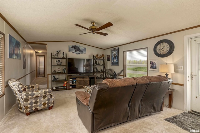 carpeted living room featuring a textured ceiling, vaulted ceiling, ceiling fan, and ornamental molding