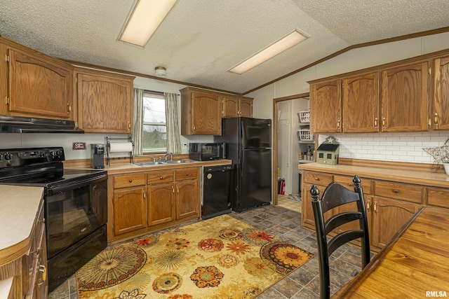 kitchen featuring tasteful backsplash, a textured ceiling, vaulted ceiling, sink, and black appliances