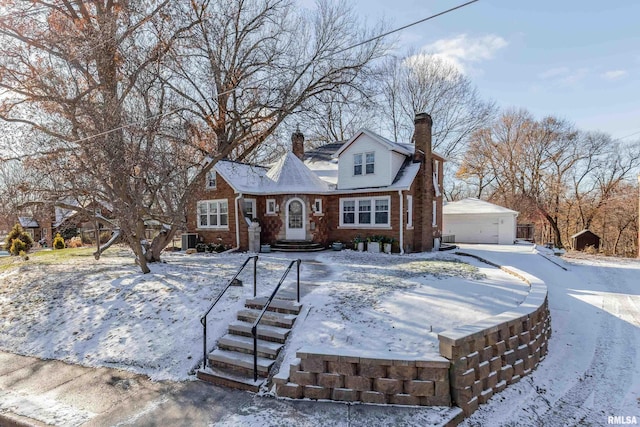 view of front of home featuring central AC unit, a garage, and an outbuilding