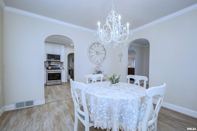 dining space featuring a chandelier, light wood-type flooring, and crown molding