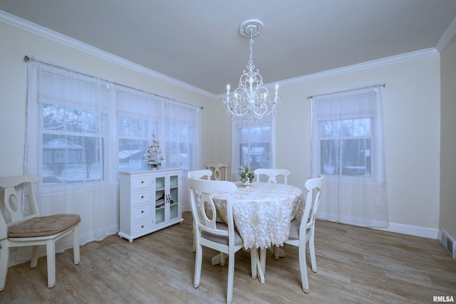 dining area with a chandelier, light hardwood / wood-style flooring, and crown molding