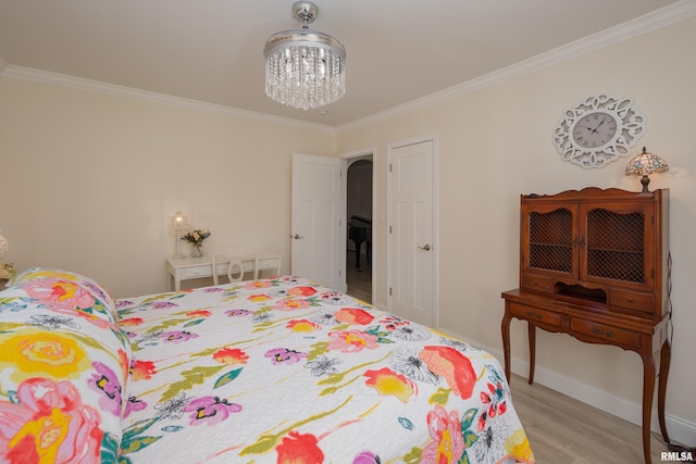 bedroom featuring light hardwood / wood-style floors, ornamental molding, and an inviting chandelier