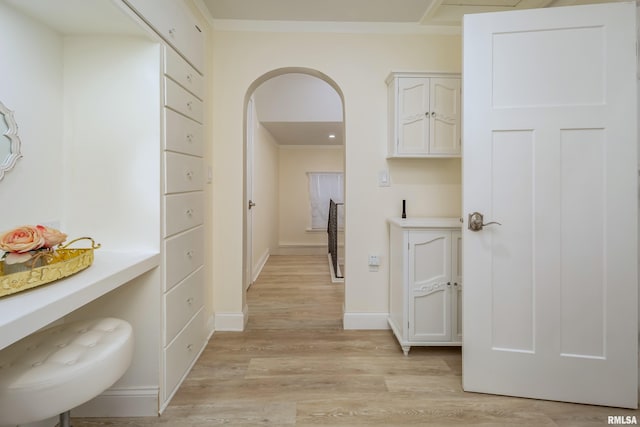 corridor featuring light hardwood / wood-style floors and crown molding