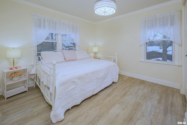 bedroom featuring ornamental molding and light hardwood / wood-style flooring