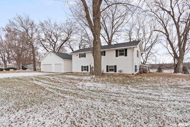 snow covered back of property with a garage