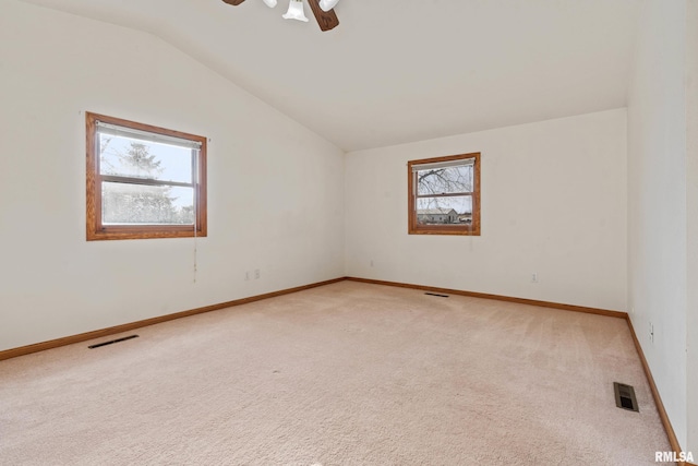 empty room featuring carpet flooring, a healthy amount of sunlight, ceiling fan, and lofted ceiling