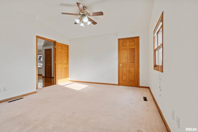 unfurnished room featuring carpet, vaulted ceiling, and ceiling fan