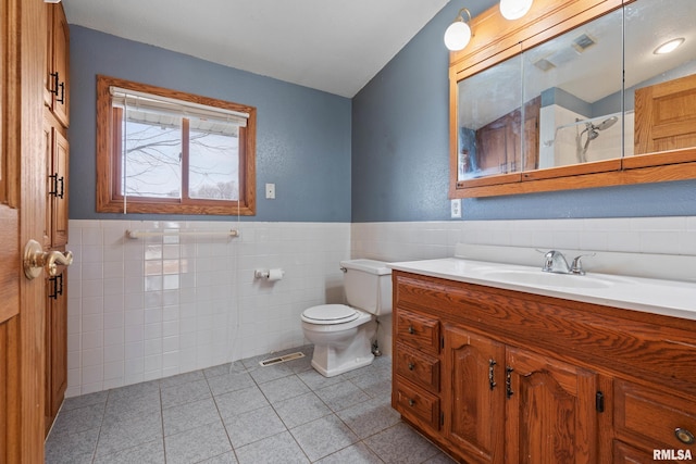 bathroom with tile patterned floors, tile walls, and toilet