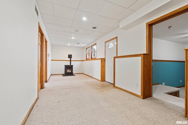 hallway with a paneled ceiling and light carpet