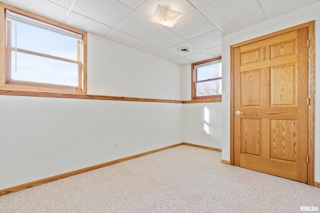 carpeted spare room with a drop ceiling