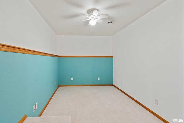 empty room featuring ceiling fan and light carpet