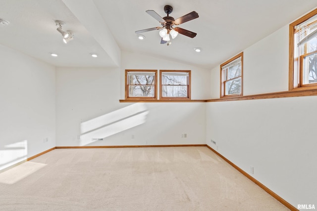 carpeted empty room with ceiling fan and lofted ceiling