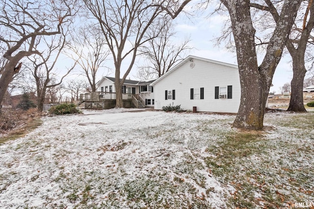 snow covered property with a wooden deck