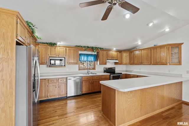 kitchen featuring kitchen peninsula, light hardwood / wood-style flooring, stainless steel appliances, and lofted ceiling