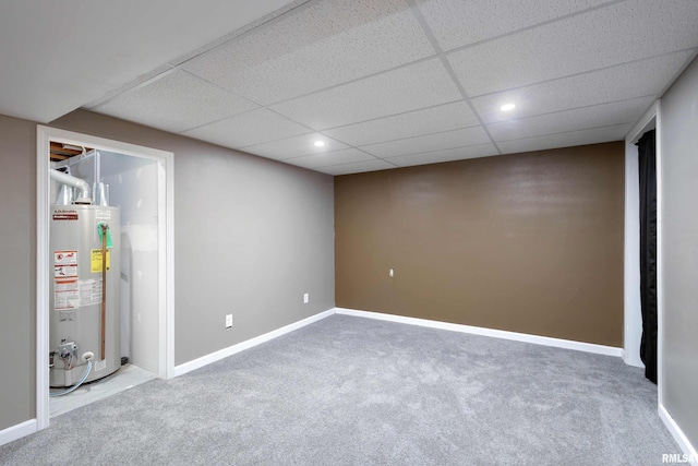 basement with carpet, a drop ceiling, and gas water heater