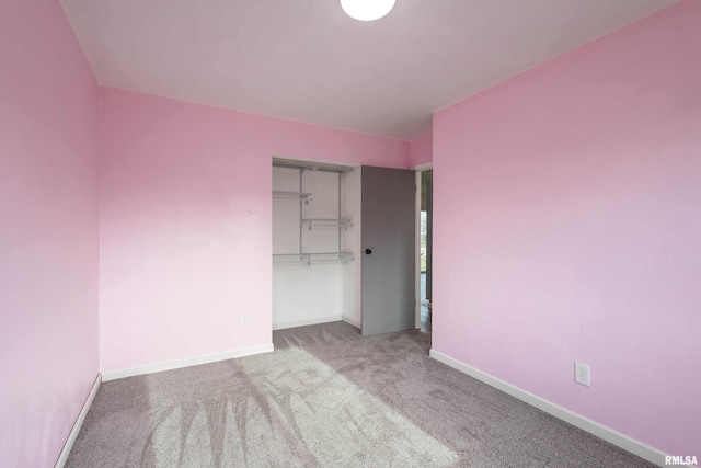 unfurnished bedroom featuring a closet and light colored carpet