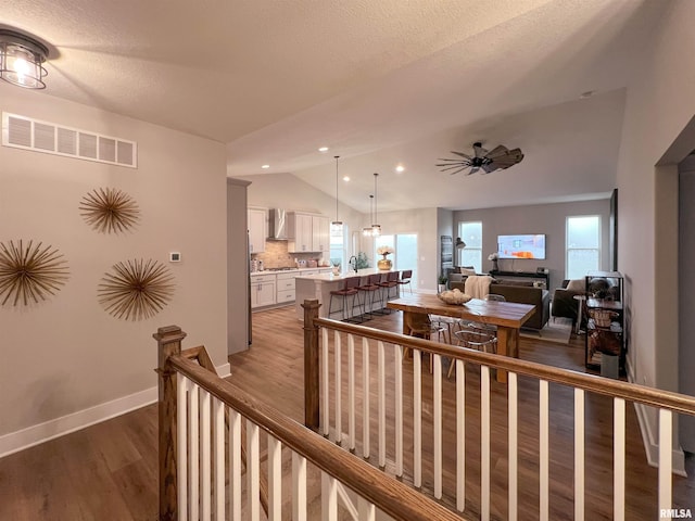 interior space with wood-type flooring, a textured ceiling, vaulted ceiling, and plenty of natural light