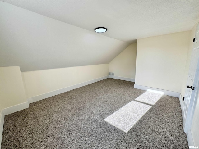 bonus room with a textured ceiling, carpet, and lofted ceiling