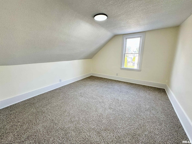 additional living space with a textured ceiling, carpet floors, and lofted ceiling