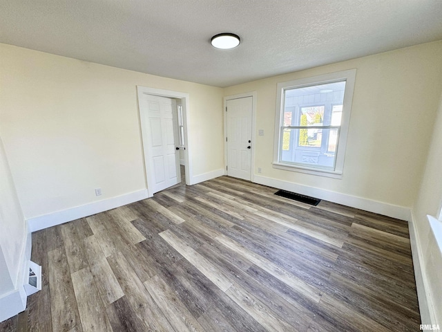 spare room with hardwood / wood-style flooring and a textured ceiling