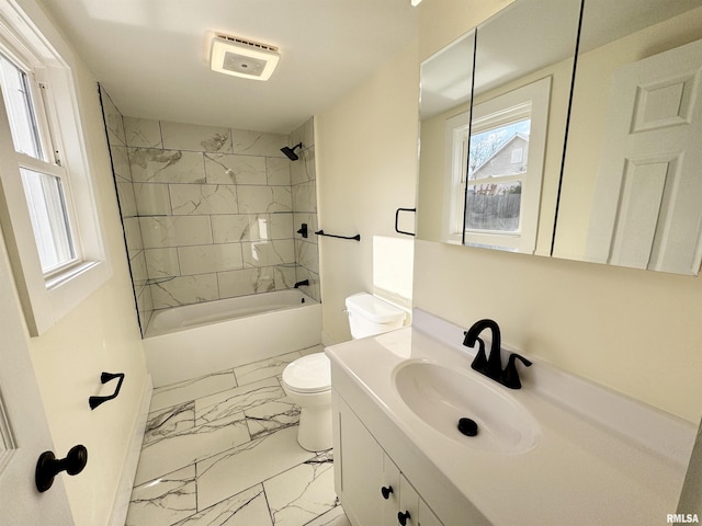 full bathroom featuring tiled shower / bath combo, toilet, and vanity