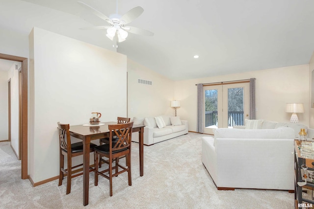 living room with ceiling fan, light colored carpet, and vaulted ceiling