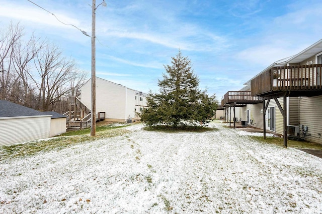 yard covered in snow featuring a deck