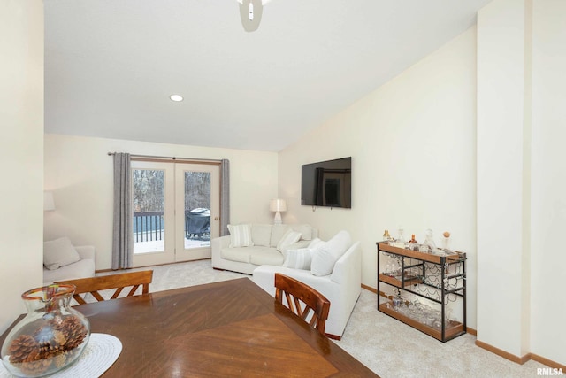 carpeted dining area with french doors and vaulted ceiling