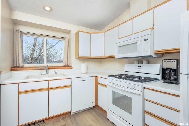 kitchen with light wood-type flooring, white appliances, sink, white cabinetry, and lofted ceiling