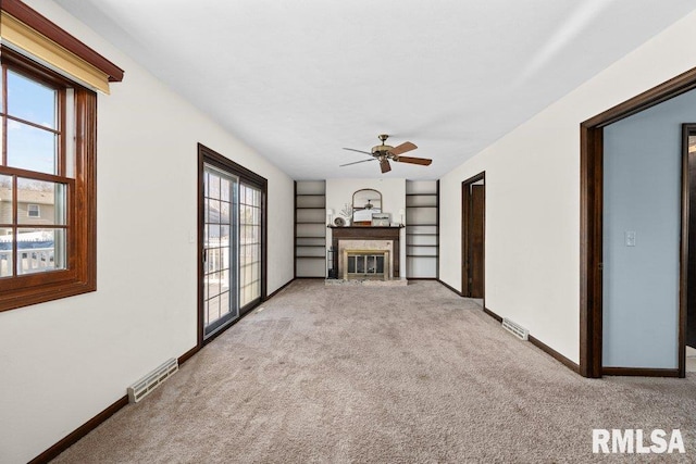 unfurnished living room featuring light carpet and ceiling fan