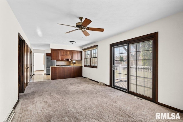 unfurnished living room with ceiling fan and light colored carpet