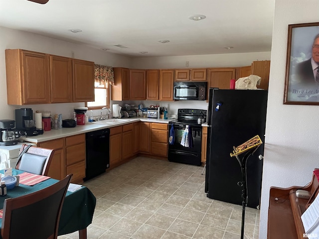 kitchen with black appliances, light countertops, and a sink