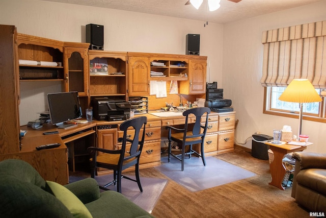 carpeted office space with ceiling fan and a textured ceiling