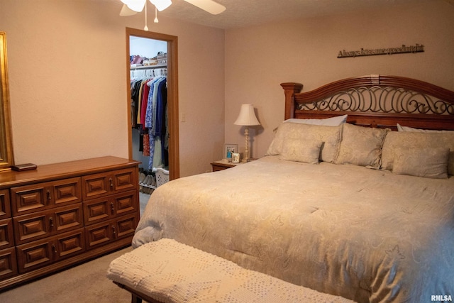 carpeted bedroom featuring ceiling fan, a closet, and a spacious closet