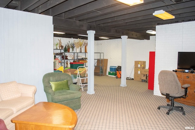 basement with carpet flooring and brick wall