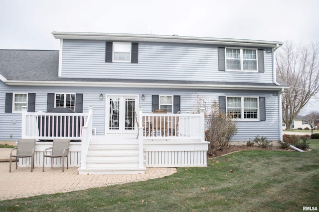 back of property featuring a lawn, a wooden deck, and a patio area