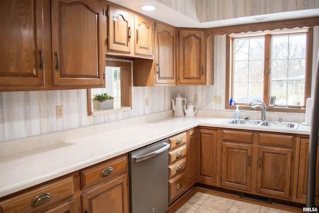 kitchen featuring dishwasher, light tile patterned floors, backsplash, and sink