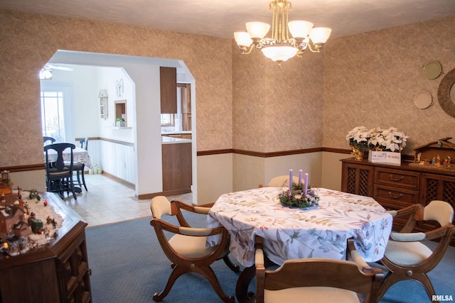 tiled dining space featuring a notable chandelier