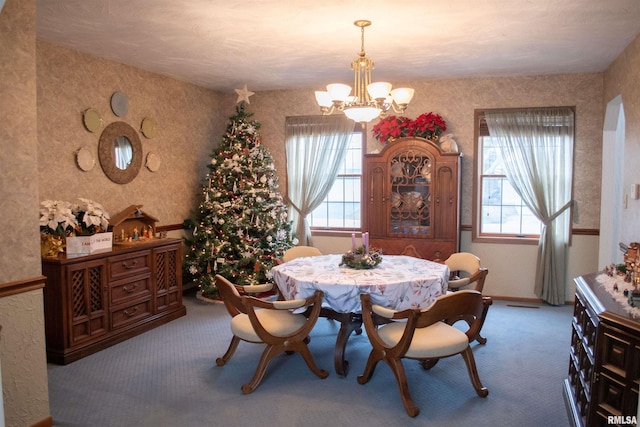 dining room with carpet flooring, plenty of natural light, and a notable chandelier