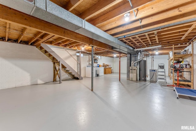 basement with water heater and washer and clothes dryer