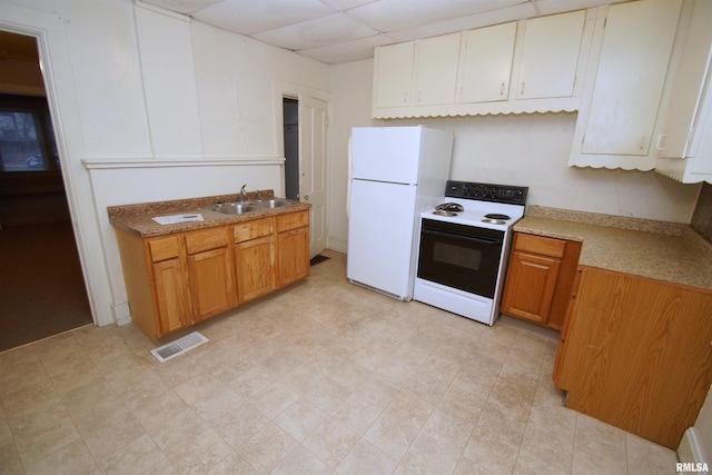 kitchen featuring a paneled ceiling, white appliances, and sink