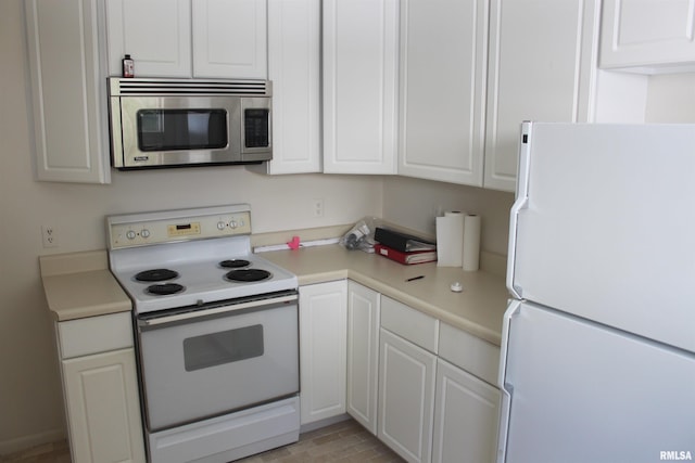 kitchen featuring white cabinetry and white appliances