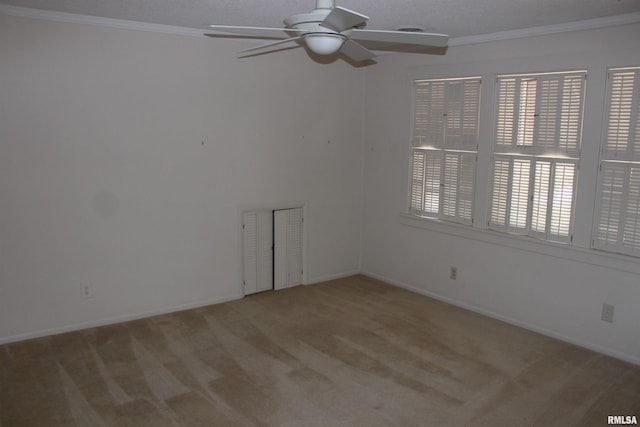 empty room with carpet flooring, a textured ceiling, ceiling fan, and ornamental molding