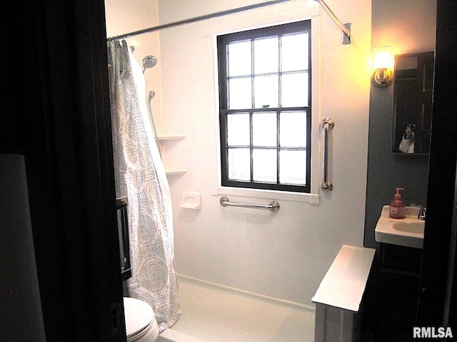 bathroom with a shower with curtain, vanity, toilet, and a healthy amount of sunlight