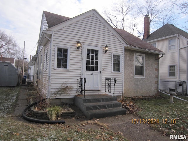 rear view of house featuring roof with shingles